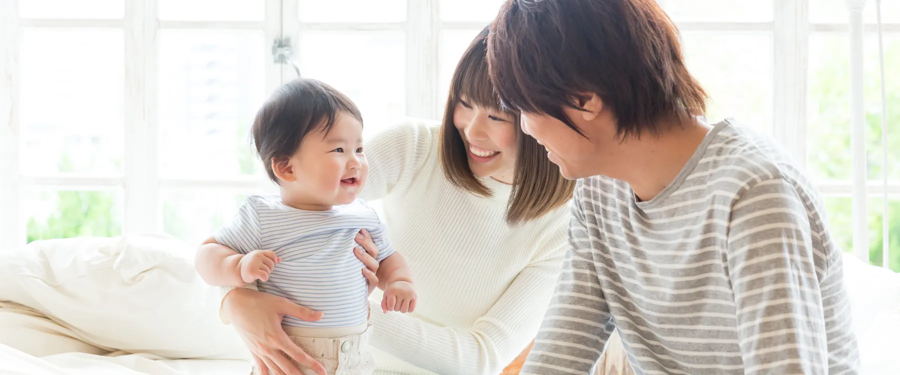 赤ちゃんと笑い合う家族