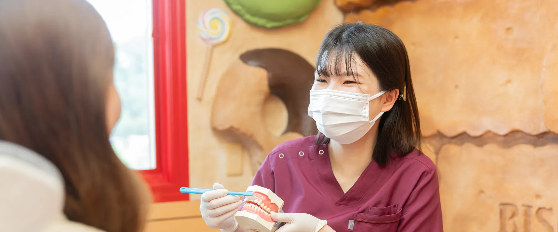 歯みがきの方法を説明する歯科衛生士